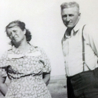 Snapshot of Mary Jessie (Cluckey) Haverkamp and Herman John Haverkamp Jr. standing outside on a farm, probably in the 1930s